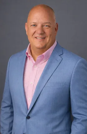 Brian Gilbert in a blue blazer and pink shirt